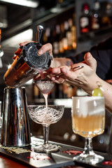 Barman makes a beautiful cocktail at the bar. The barman whipped the cocktail