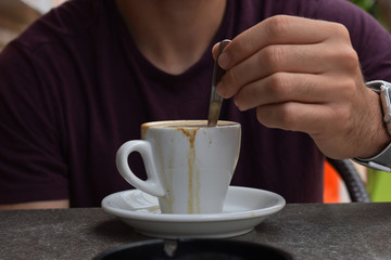 Removiendo un cafe en la terraza de un bar