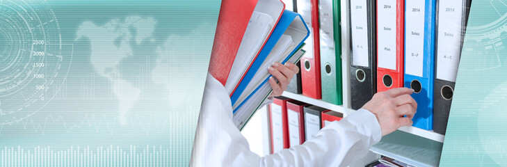 Businesswoman taking binders from a shelf; panoramic banner