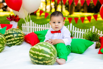Fototapeta na wymiar Happy child with watermelon. Happy Infant smiling. Little boy playing in the garden biting a slice of watermelon
