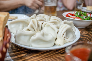 Top view of traditional Georgian lunch: khinkali, bread, vegetable salad