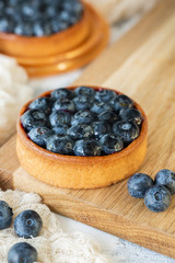 Tart with blueberries on wooden board