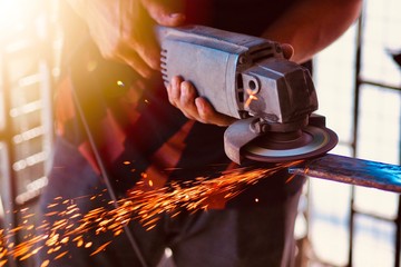 The craftsman is grinding or cutting steel with the tools he holds in his hand. Working tools cause...