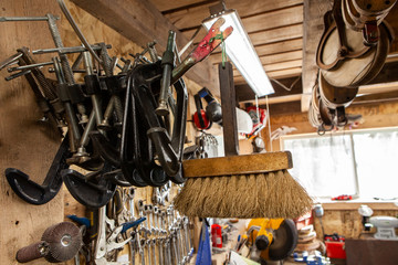 G-clamps hanging in a metal workshop. A closeup view of G-clamps hung inside a metalwork garage....