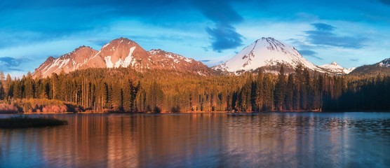 Manzanita Lake in Lassen Volcanic National Park with reflection of mountains and blue sky in the...