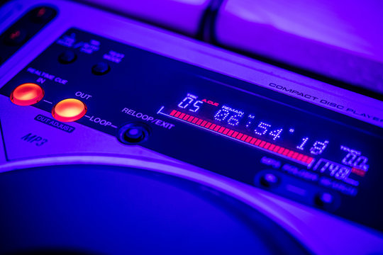 Closeup of digital LED time display on a CD Player. Blue stage lighting.
