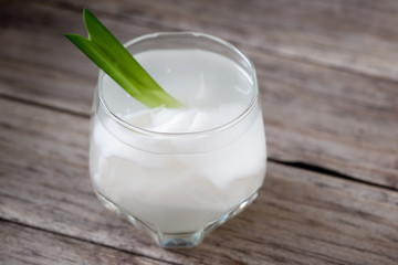 Fresh coconut juice in a glass with coconut white meat isolated on white