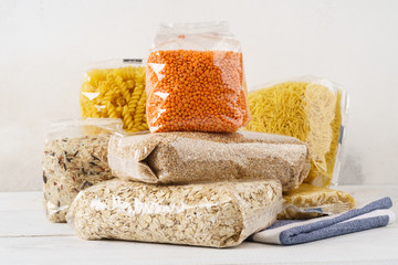 Various raw groats, cereal grains and pasta in plastic bags.