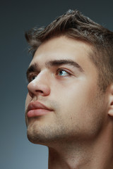Fototapeta premium Portrait of shirtless young man isolated on grey studio background. Caucasian healthy male model looking at side and posing. Concept of men's health and beauty, self-care, body and skin care.