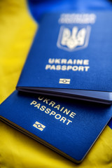 Two Ukrainian biometric passports against the background of the Ukrainian blue-yellow flag.