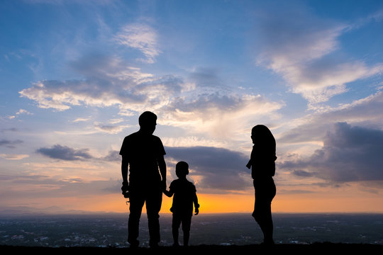 Silhouette happy family on sunset background