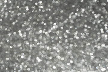 Abstract blurred background of glitter light of silver color.