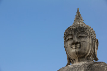 Fototapeta na wymiar Buddha face in blue sky background, Buddha statue in Thailand.