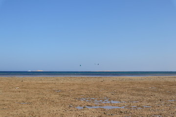 Strand, blaues Wasser und blauer Himmel