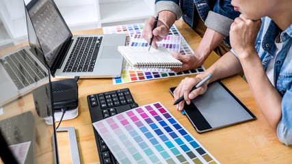 Team of young colleagues creative graphic designer working on color selection and drawing on...