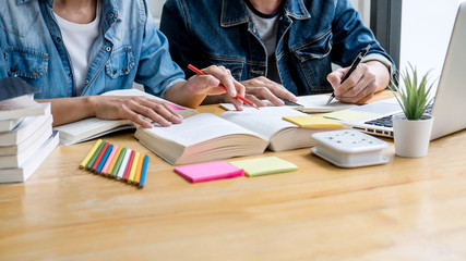 Education, teaching, learning, technology and people concept. Two high school students or...