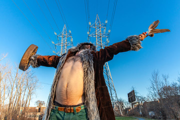 Sacred man beneath electricity towers. A front view of a spiritual man as he meditates, standing...