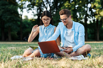 young couple with laptop in the park