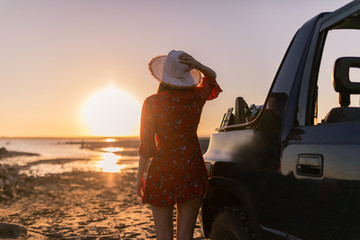 girl with happy hat at sunset on the beach