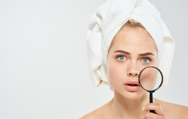 woman with towel on head magnifier skin care