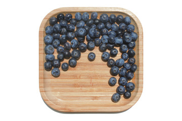 Ripe juicy blueberry on wooden plate. Food summer background