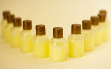 Little cute soft yellow bottles of cream for face, body, hair. Personal beauty care and anti-aging treatments, anticellulite care.