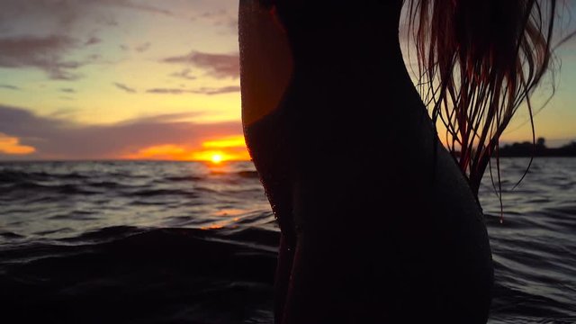 Close up silhoutte of young woman body in the water.