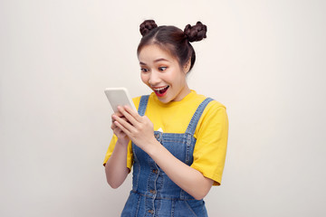 Nice vivid girlish happy smiling girl reading sms notification about winning, isolated over white background