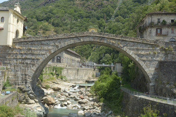 Fototapeta na wymiar The ancient Gallia road and the Roman bridge in the town of Pont St Martin in the Aosta Valley - Italy