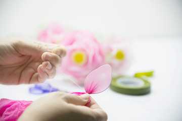 Obraz na płótnie Canvas Woman making beautiful nylon flower - people with DIY handmade flower concept