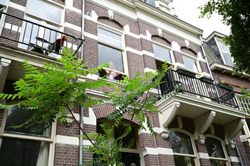 Fototapeta premium Dutch student girl opening the front window of her student house in Amsterdam, The Netherlands