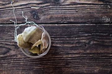 infuser with used tea bags on black wooden table