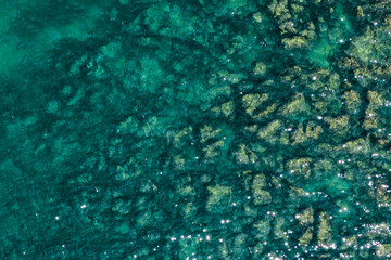 Fototapeta na wymiar Aerial view of rocky seaside. Rocky stones in the ocean. Aerial photography of beautiful rocky seashore.