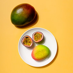 Creative layout made of mango cheesecake and passion fruit on yellow colored background, minimal flat lay style. Food concept. Colorful fruit top view.