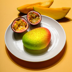 Creative layout made of mango cheesecake and passion fruit on yellow colored background, minimal flat lay style. Food concept. Colorful fruit top view.