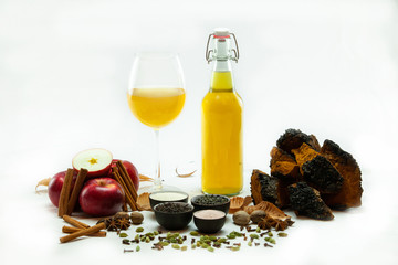 Organic & healthy homebrew mushroom tea. The unprocessed elements of green Kombucha tea are seen close up, isolated against a white background with copy-space. A healthy refreshment commonly homemade