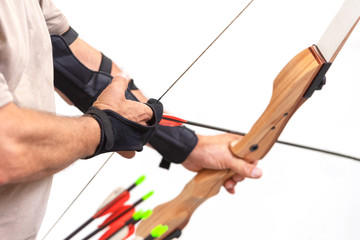 Archer close up, preparing the arrow for the shot, on white isolated background .