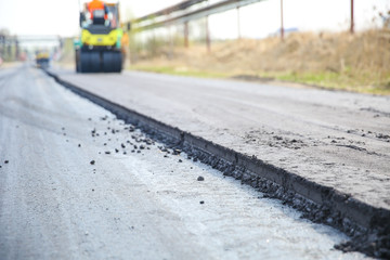 asphalt paving works on the street close up. new asphalt layer on the road