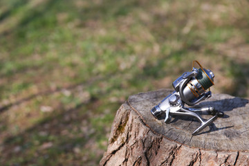 background of silver fishing reel on the stump with copy space.