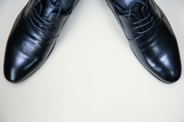 black leather men's shoes with laces on a light background with free space