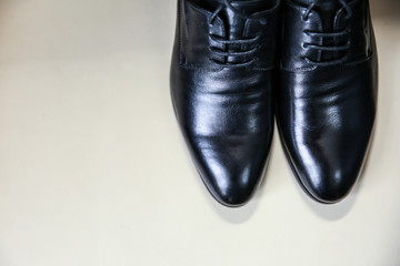 Black leather men`s shoes with laces on a light background with free space
