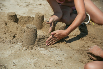 playing with children on the beach. building a sand castle close up.