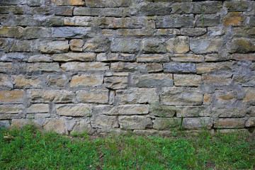 stone wall background. texture of vintage gray brick wall with grass