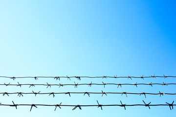 background of barbed wire on the background of blue sky