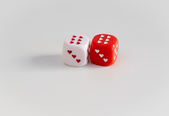 Two dice with hearts: white and red on the table. Gambling