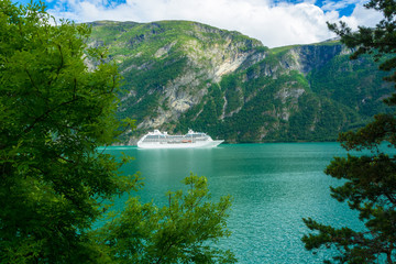 A large cruise ship sailing through a Norwegian fjord, southern Norway