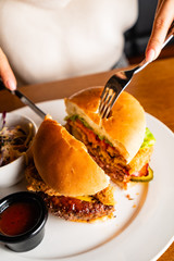 .Young woman eating burger in restaurant