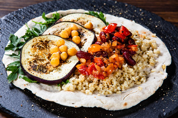 Groats with sauce and vegetables on tortilla