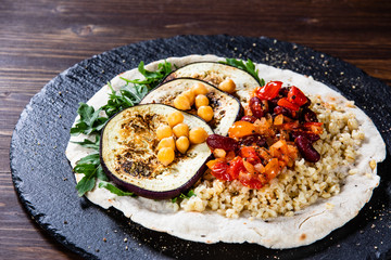 Groats with sauce and vegetables on tortilla
