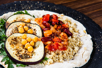 Groats with sauce and vegetables on tortilla